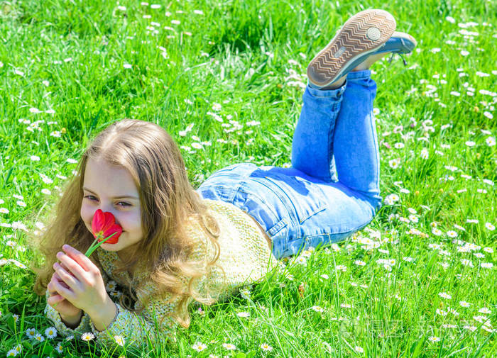 在阳光明媚的春天, 微笑的女孩捧着红色的郁金香花.