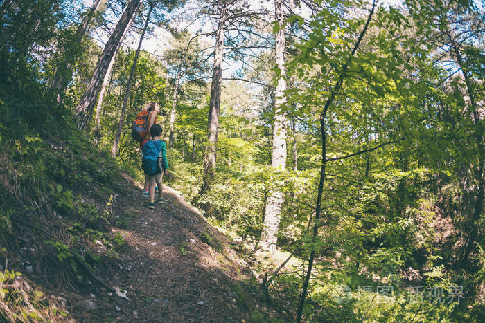 一个女人和她的孩子沿着森林小径散步.