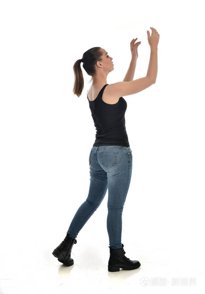 穿黑色单身牛仔裤的黑发女孩的全长肖像站立姿势侧轮廓孤立在白色工作