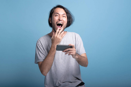 亚洲年轻人玩手机游戏半身体射击. 年轻一代嬉皮士放松的概念.照片