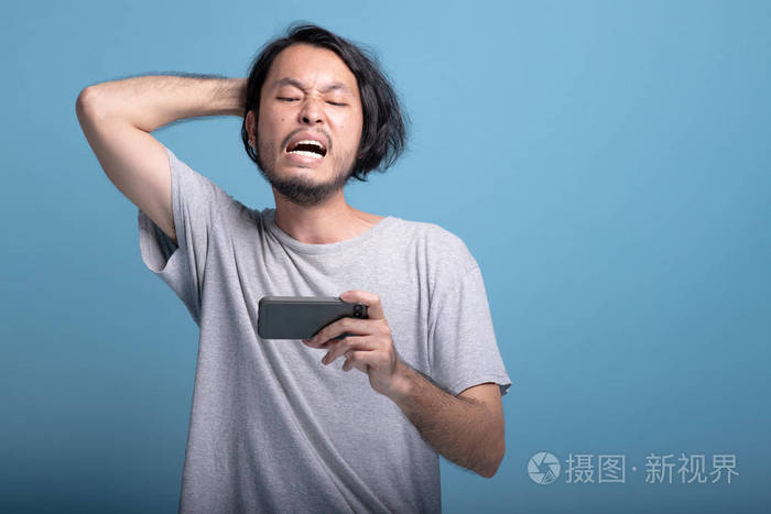 非常失望的亚洲年轻人玩手机游戏半身体射击. 年轻一代的时髦概念.