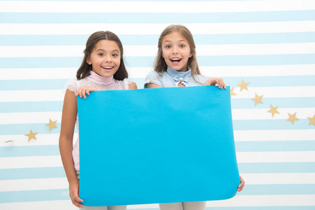 孩子们做广告。广告你的产品。微笑的小女孩们拿着蓝色广告海报来复制空间。蓝色纸的小女孩