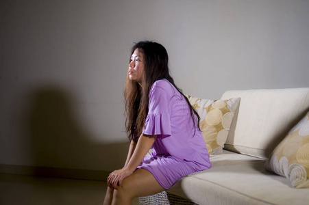 年轻的悲伤和沮丧的亚洲韩国妇女在家沙发沙发上哭泣，绝望和无助，痛苦，焦虑和抑郁，感觉痛苦的关系和孤独的生活问题概念