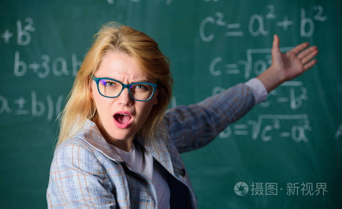 女人戴眼镜,智能教师教室,黑板背景关闭. 老师想知道结果.
