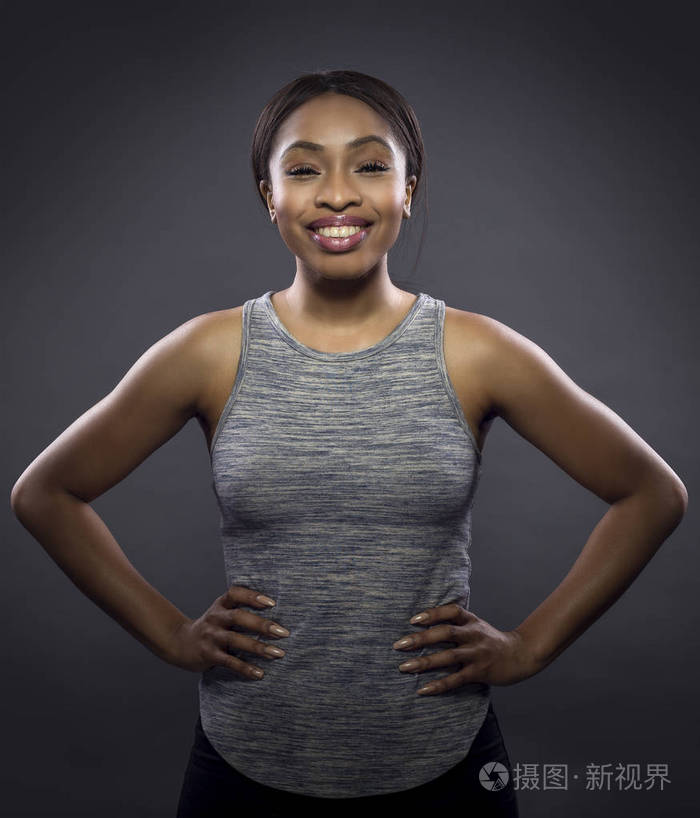 黑色健身教练或运动员在黑暗的背景下冒充一个坚韧的女人她又健康又