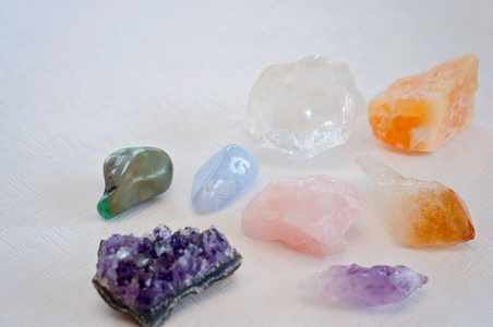 五颜六色的愈合晶体带来积极的振动蓝色花边玛瑙紫水晶，清晰的石英，香橼，方解石和玫瑰夸脱在白色的桌子上。