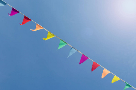 悬挂在外面的绳子上的彩旗,与明亮的蓝天节日一起照片