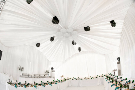 婚礼餐厅的帐篷内部, 为客人准备。服务圆形宴会桌室外在天棚装饰绣球花, 金黄菜和绿色餐巾。餐饮理念