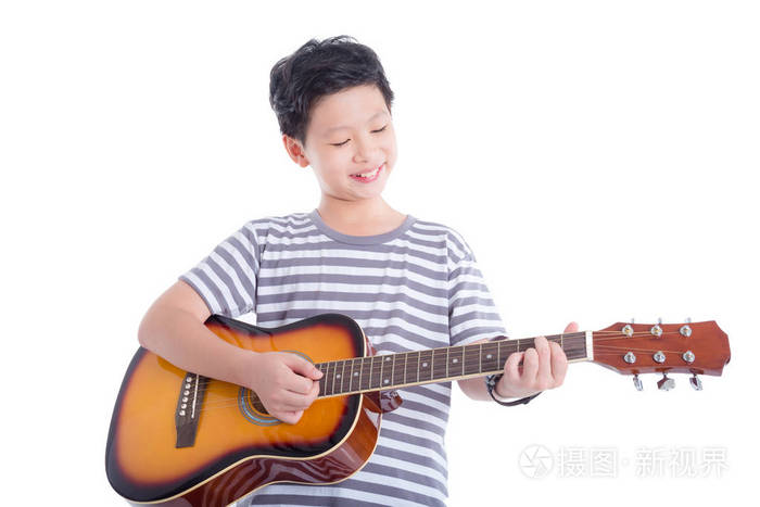 年轻的亚洲男孩弹吉他,在白色背景下微笑