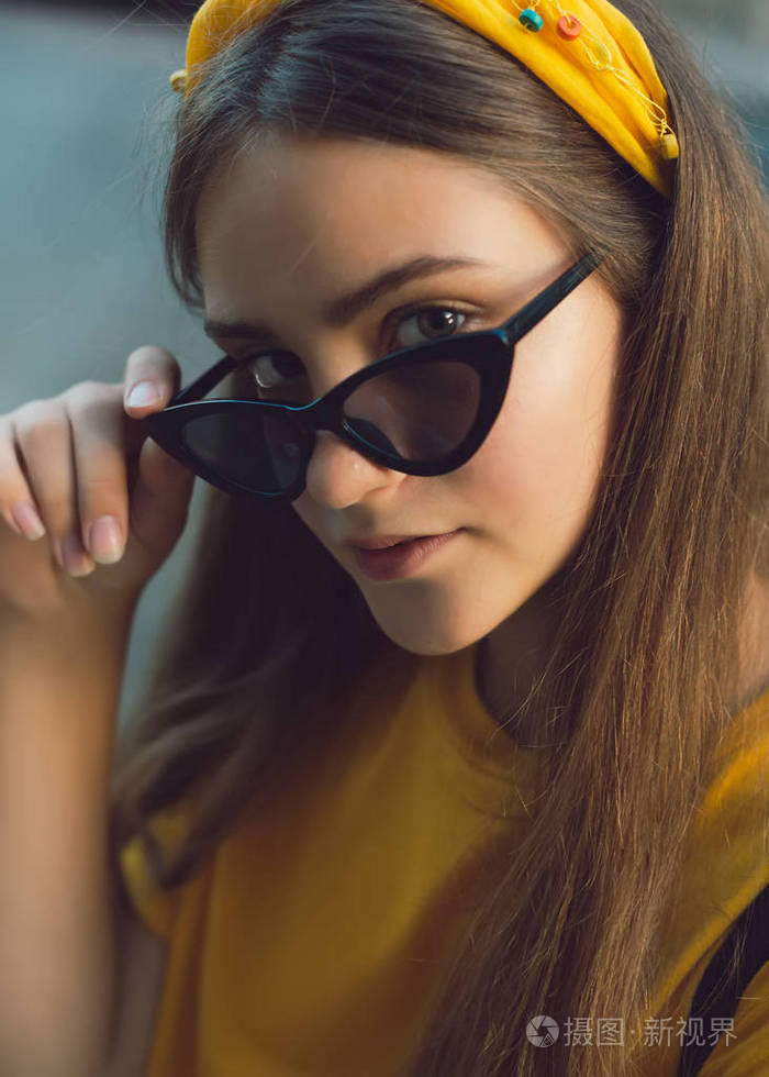 年轻漂亮的女人在灯光背景下看着相机. 女孩肖像. 美女肖像的少女.