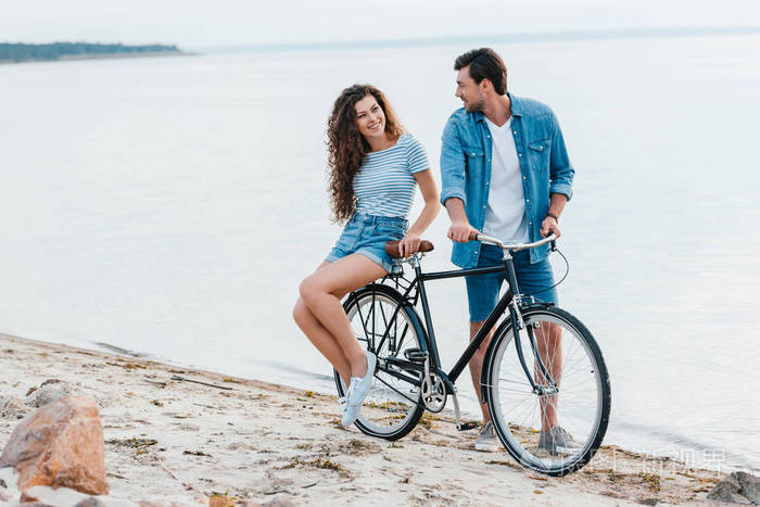 一对夫妇一起在海边的海滩上骑自行车照片-正版商用图片12j7iv-摄图新