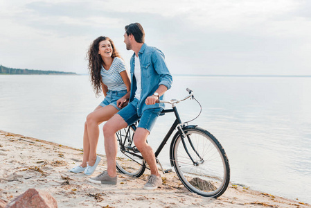 快乐的一对夫妇骑自行车在海边