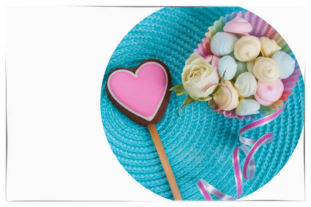 爱情的象征, 粉红色的姜饼饼干在形状一颗心, 糖果, 装饰着新鲜的嫩玫瑰在绿松石背景
