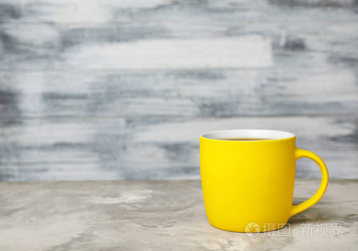 黄色陶瓷杯，桌上有热的芳香咖啡