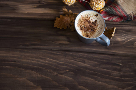 秋季热巧克力杯顶部的木质背景与秋季装饰和毛毯与复制空间