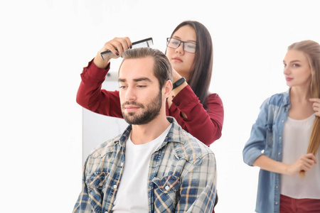 专业理发师和受训人员在沙龙与客户合作。 学徒概念
