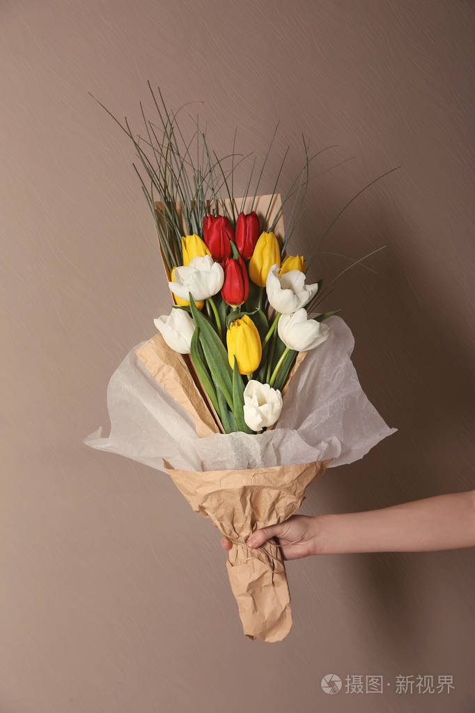 女人拿着漂亮的花作为礼物的颜色背景