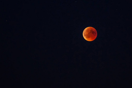 月亮在星空中带着血红的颜色，因为月食通过地球。