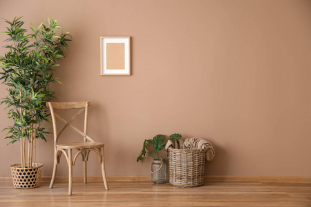 带柳条篮子的木椅和靠近彩色墙壁的植物