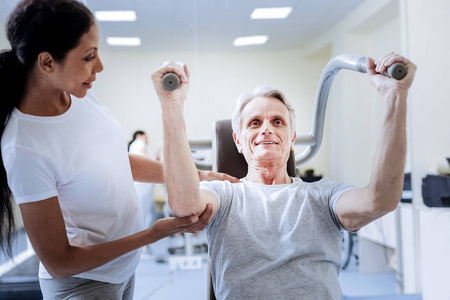 医生看腰部细心亲切的医生看她的病人在康复中心照片