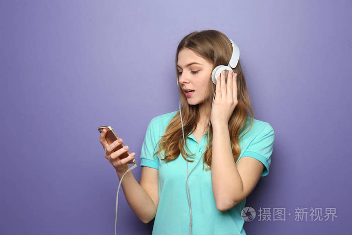 在彩色背景下听音乐的年轻美女