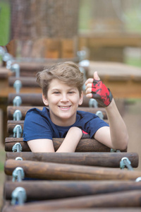运动可爱的小男孩来到冒险绳公园，在他的暑假或春季假期玩得很开心