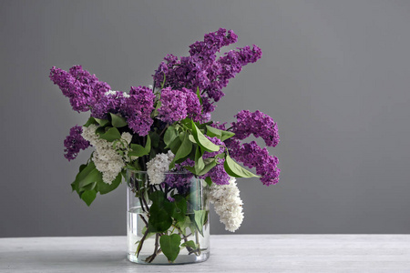 在灰色的背景下，桌上放着一朵美丽的紫薇花瓶