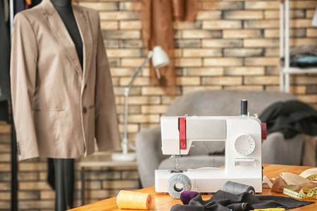 s workplace with sewing machine and mannequin in atelier