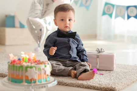 房间里地板上有生日蛋糕的可爱小男孩