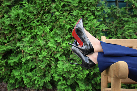 年轻女子穿着时髦的鞋子在户外长凳上休息