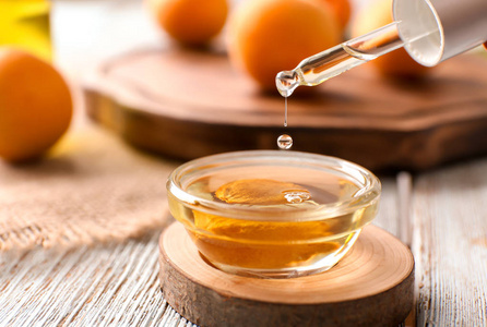 把杏子精油滴到桌上的碗里照片
