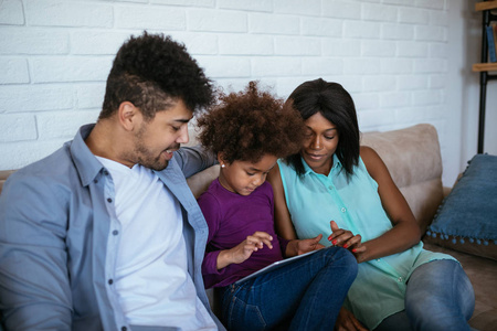 非裔美国人家庭享受在一起和使用数字平板电脑的时间。
