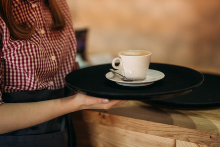 服务员在咖啡馆里提供一杯咖啡。cappuchino