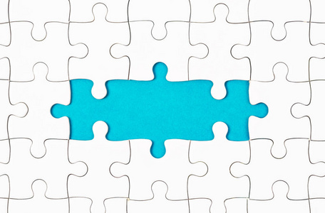 未连接蓝色背景下未完成的白色拼图碎片照片