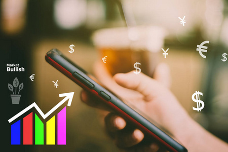 芬特科技各种货币标志图标和市场股票图表屏幕的智能手机与彩色Bokeh模糊背景。 金融商业技术自由梦想生活使用互联网概念。