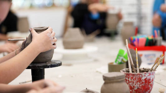 用粘土工作的学生把手弄脏了 视觉艺术课显示手在一个线圈锅与粘土工具和桌子的背景 学校的艺术教育 创造力 教学陶瓷 课堂照片 正版商用图片12klsa 摄图新视界 用粘土工作的学生把手弄脏了 视觉艺术课显示手在一个线圈锅与粘土工具和桌子的背景 学校的艺术教育 创造力 教学陶瓷 课堂照片 正版商用图片12klsa 摄图新视界