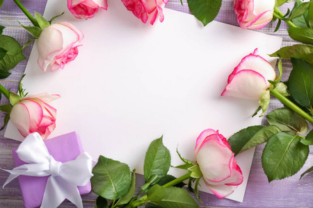 木制桌子上的漂亮玫瑰礼盒和空白贺卡