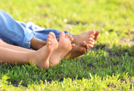 可爱的赤脚孩子躺在户外草地上
