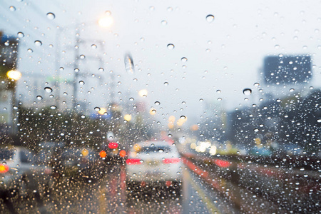 透过车窗看路,雨滴在雨中行驶透过玻璃看到后视镜.车窗湿了.关闭雨滴.