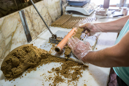 男人手准备传统的Lok或Tatuni甜点。Lok甜点是通过混合干燥的桑椹地板和核桃，然后捣碎3小时。 凯玛利耶图基。