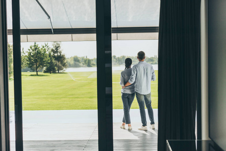 朋友背影在乡间别墅门廊拥抱女朋友的背影照片