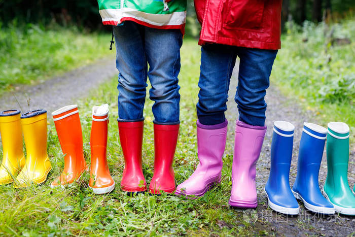 小朋友们孩子们穿着五颜六色的雨靴孩子们站在秋天的森林里学童和不同