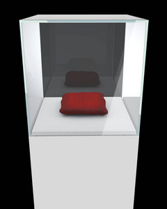 玻璃展示立方体与红色枕头隔离在黑色背景。