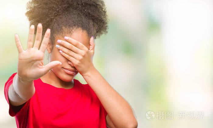 年轻的美国黑人妇女在孤立的背景上用手遮住眼睛，用悲伤和恐惧的表情做停止的手势。 尴尬和消极的概念。