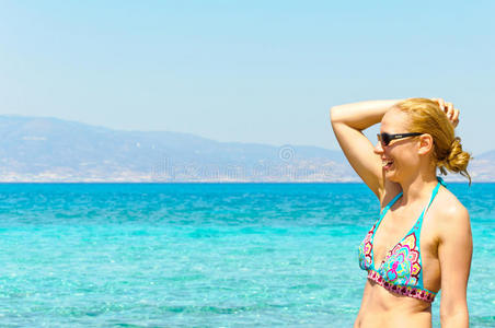 穿着泳装的美丽年轻女子，在热带阳光明媚的海滩上放松