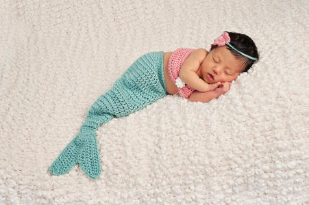 穿着美人鱼服装睡觉的新生女婴图片