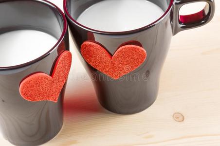 木桌上装饰心形的牛奶杯，情人节的概念
