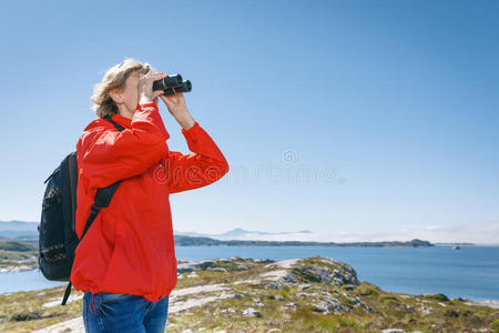 女游客用双筒望远镜观察