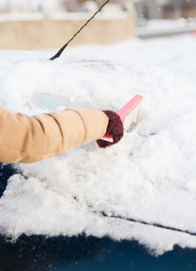 女人在擦车后窗上的雪