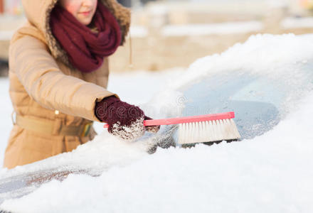 女人在擦车后窗上的雪